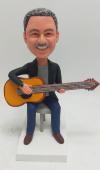 Custom bobblehead sitting with guitar